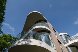Modern exterior of a building with curved glass and concrete