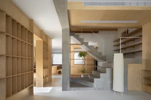 A minimalist interior design featuring a concrete staircase with wood shelves and a large floor lamp.
