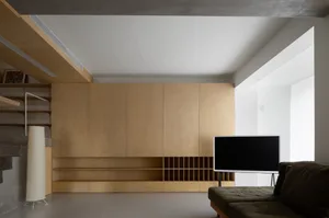 Modern living room featuring minimalist design with wood accents and concrete elements