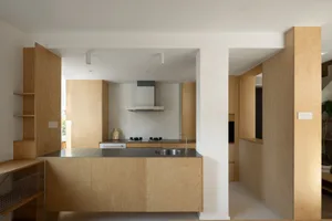 Modern minimalist kitchen with wooden cabinets and a stainless steel countertop.