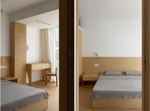 A minimalist bedroom with wooden furniture and a white bedspread.