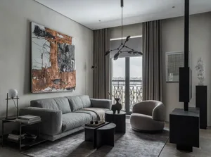 Modern living room with minimalist furniture, abstract art, and a stylish chandelier.