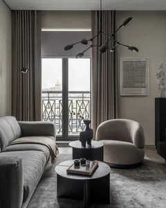 Modern interior design featuring a textured fabric sofa, glass coffee tables, and minimalist decor.