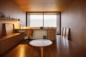 A modern office space featuring wooden interiors and a large desk with a chair.