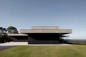 Modern residential building with wooden exterior, glass windows, and concrete roof