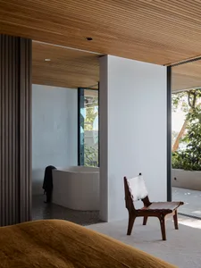 Industrial bathroom with concrete walls and floor, featuring a standalone bathtub next to large windows.