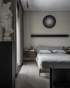 Modern bedroom with a cozy layout, showcasing a textured wooden floor, soft fabric bedding, and sleek metal accents.