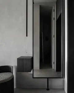 Modern interior with concrete walls, floor, and floating cabinet.