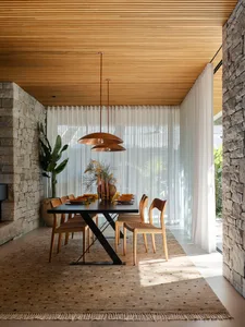 Modern dining room featuring wooden furniture, leather accents, and stone elements.