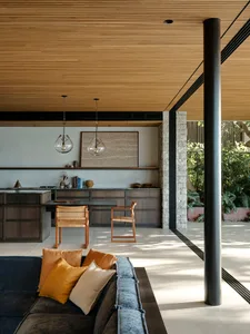 Modern living room with wooden ceiling and furniture.