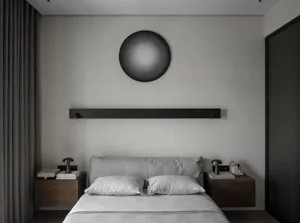 A minimalist bedroom featuring a bed with bedside lamps and minimalist decor.