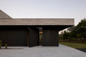 An image showcasing a modern house with a dark wood exterior.