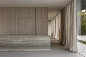 Modern lobby with glass walls and floor, featuring a minimalist design.