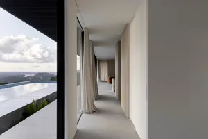 現代簡約走廊，混凝土牆面搭配白色窗簾，可見雲海與山景。