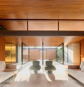 A modern living room featuring wooden walls and furniture.