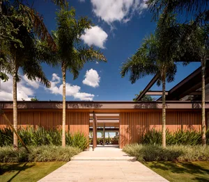 Modern residential exterior with tropical landscaping and wooden elements.