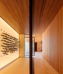 Modern wine cellar with wooden walls and ceiling, showcasing stylish wine bottle storage.