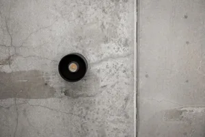 Industrial light fixture mounted on a concrete wall.