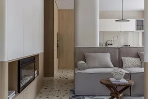 Modern minimalist living room with a terrazzo cement floor, upholstered sofa, and a built-in fireplace