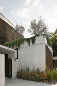 Modern home with white walls, concrete exterior, and wooden accents.