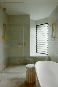 A modern minimalist bathroom featuring tile and marble surfaces.