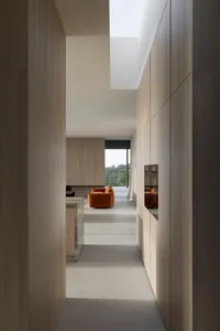 A modern, minimalist residential interior featuring light wood finishes.