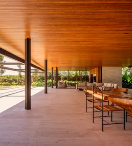 A modern residential patio with a wooden ceiling and seating area.