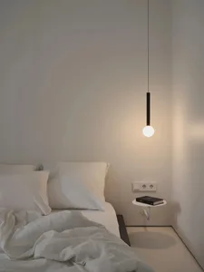 A minimalist bedroom featuring a white bed with curtains, a glass pendant light, and minimalistic furnishings.