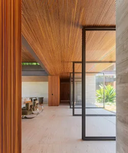 A modern residential interior featuring minimalist design elements, concrete and wood finishes, and expansive glass windows.