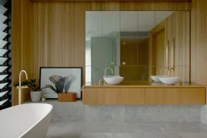A modern bathroom featuring wooden interior design elements and a contemporary sink and mirror setup.