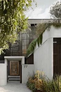 A modern house facade with vertical garden and concrete walls.