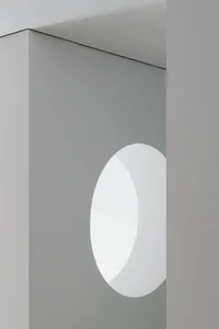 Minimalist interior design featuring a circular cut-out wall in light-grey concrete