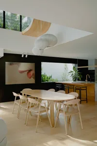 A modern living room featuring wooden furniture, large windows, and a minimalist design.