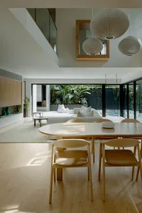 Modern living room with wood flooring and tile accents, featuring sleek furniture and minimalist decor.