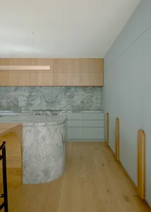 A modern kitchen with marble countertops and minimalist design.