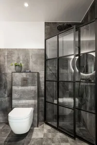 Modern minimalist bathroom with concrete tiles and a white toilet.