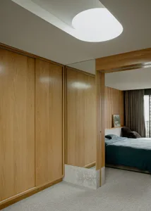 A modern minimalist bedroom featuring wooden furniture and glass elements.