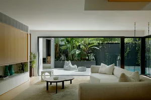 A modern minimalist living room featuring floating furniture, white accents, and a view of a tropical garden with a floating 