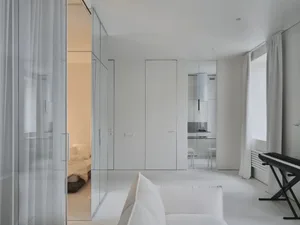 Modern minimalist living room with white walls, furniture, and materials.