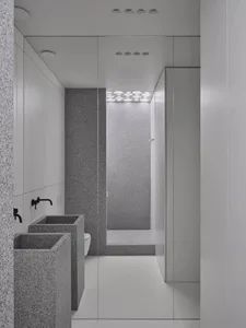 Minimalist grey granite bathroom interior with white floor and black fixtures