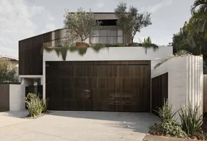 A modern house with metallic door, concrete walls, and greenery on rooftop.