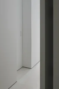 A minimalist bedroom with concrete walls and floor.