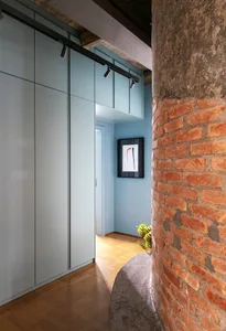 A minimalist interior space with concrete walls, a wooden floor, and a plant.