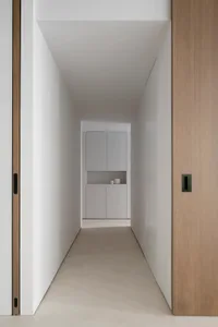 A minimalist corridor with wooden walls and a concrete floor.