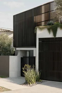 Modern metal facade with white concrete accents and vertical slat elements.