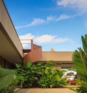 Modern interior design featuring concrete walls and floors, with green plant-life in foreground.