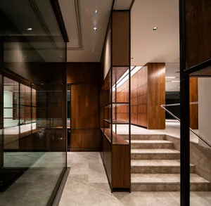 An elegant modern office library features a staircase with wooden panels and marble steps.