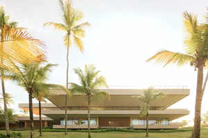 Modern residential building made of concrete, surrounded by palm trees.