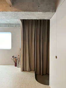 A modern residential bathroom featuring concrete walls and wooden accents.