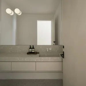 Modern bathroom interior with concrete vanity and countertop, minimalistic design, and integrated sink.